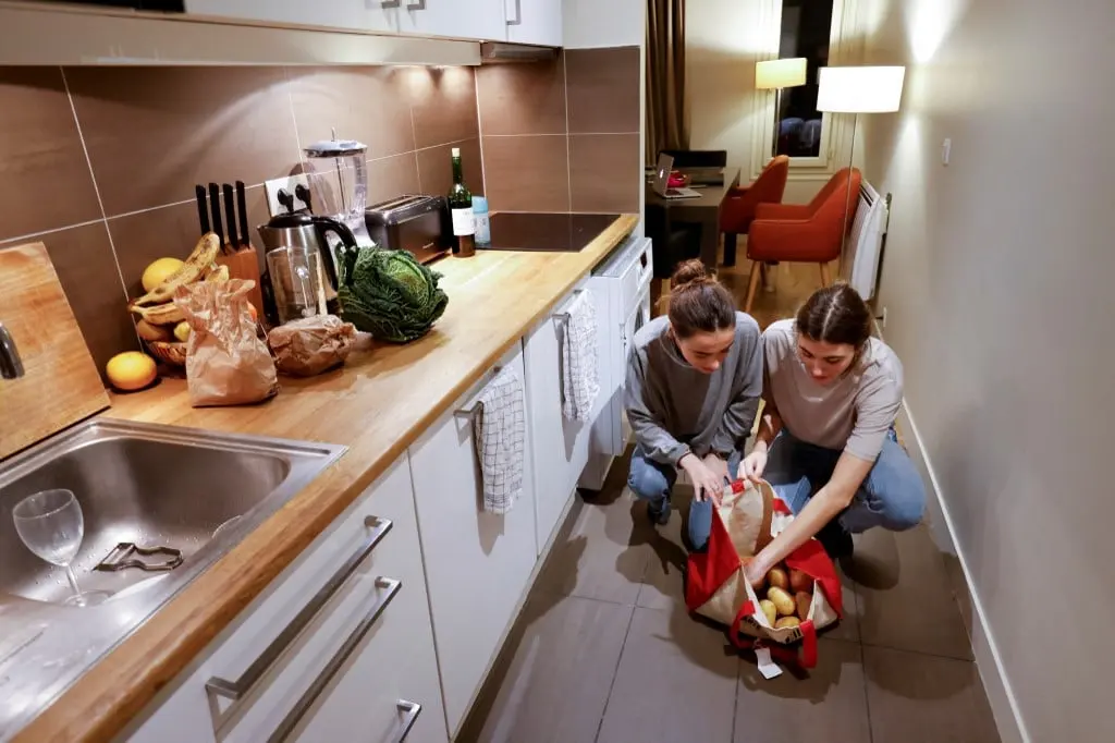 Foto de arquivo de dois inquilinos fotografados na cozinha de seu apartamento. Foto de Ludovic MARIN / AFP
